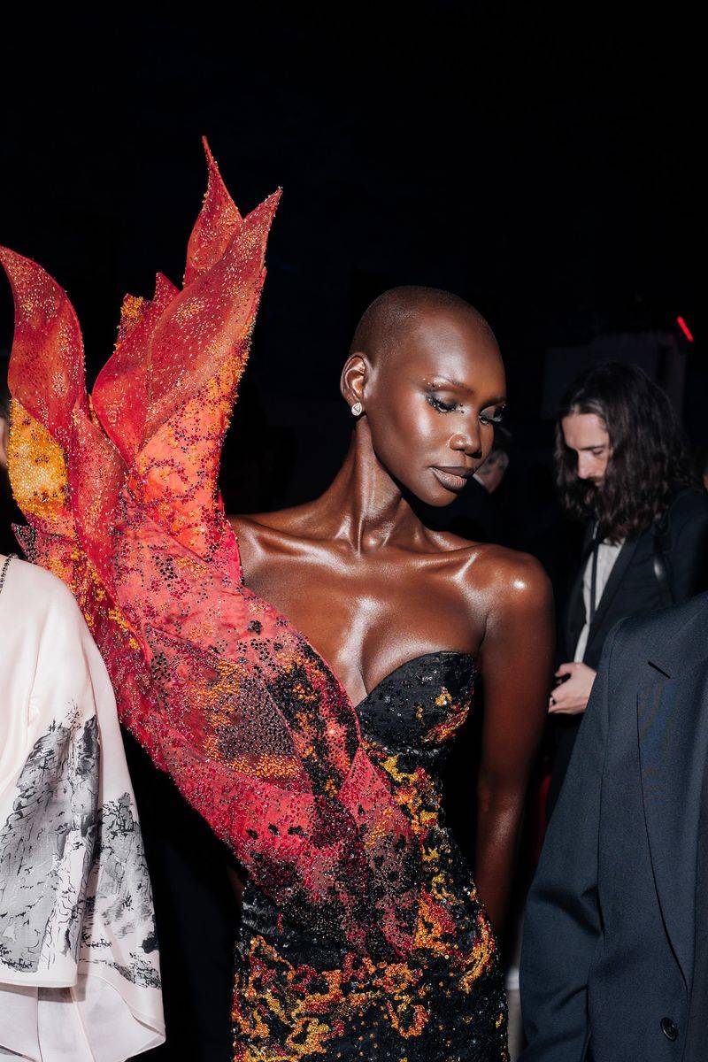 Image may contain: Alek Wek, Oscar Dronjak, Adult, Person, Clothing, Formal Wear, Suit, Wedding, Photobombing, and Fashion