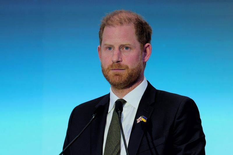 Image may contain: Prince Harry, Duke of Sussex, Accessories, Formal Wear, Tie, Electrical Device, Microphone, and Crowd